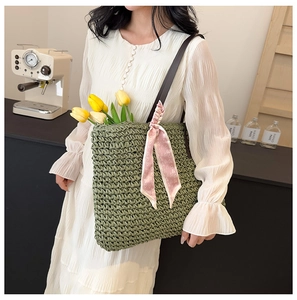 Detail of green straw tote bag with pink heart scarf and tulips for summer beach style