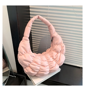 Detailed view of the pleated pink cloud bag with quilted matte faux leather texture