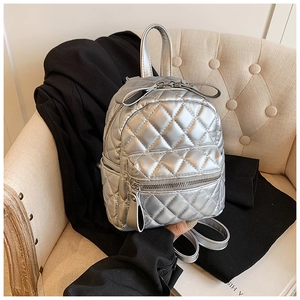 Detail of silver quilted backpack with metallic finish and smooth zipper textures