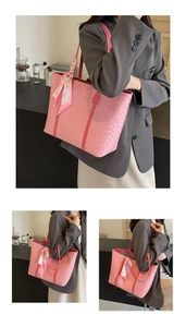 Detail view of pink woven tote bag with silk scarf on the handle for women