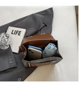 Detail view of the spacious inner compartment with leather and fabric patchwork design