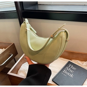 Close-up of mint green crescent bag with pleated texture and light gold hardware