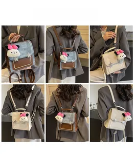 Detail view of mini backpack with star rivets and plush mascot on a stylish denim patchwork