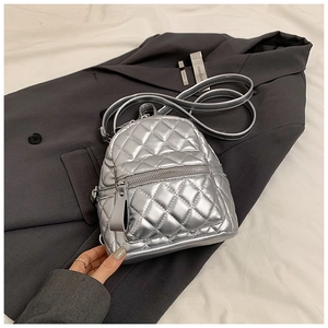 Detail of silver metallic quilted mini backpack with rhombic pattern and front zipper