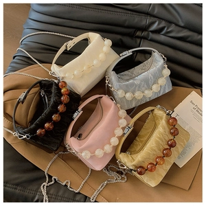 Detail van mini-crossbodytassen met acryl kralenbandjes in vijf verschillende kleuren