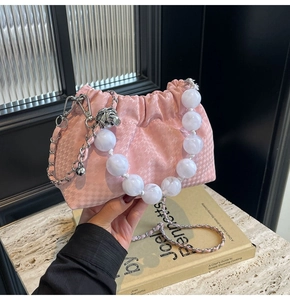 Pink pleated cloud bag with white beaded handle and silver chain strap detail shot