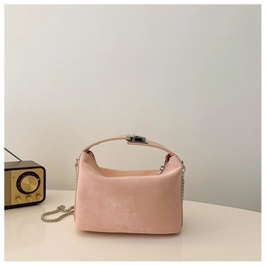 Detail van roze matte crossbodytas met zilveren ketting en metalen drukknoopsluiting