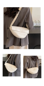 Detail view of beige ruched croissant bag with textured leather and adjustable strap