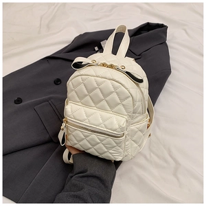Close-up of white quilted mini backpack with golden zipper and luxury PU leather texture