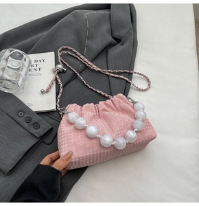 Detailed close-up of pink houndstooth pleated bag with marble bead handle and chain strap