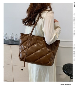 Detail of deep brown quilted tote bag in premium leather with diamond lattice pattern