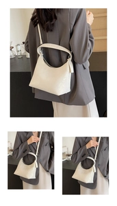 Detail of off-white crescent hobo bag showing leather texture and adjustable strap