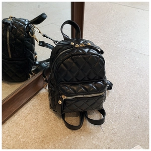 Detailed view of the black quilted leather mini backpack with gold-tone hardware and zippers