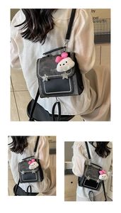 Detail of grey crossbody bag with silver star buckle, pearl trim and plush rabbit charm