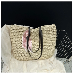 Detailed close-up of handmade woven straw tote bag with decorative pink heart scarf
