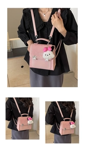 Detail of pink multi-functional backpack showing bead trim and plush puppy charm