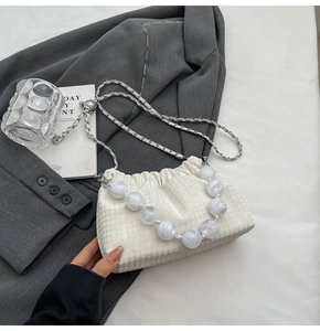 Detail of white houndstooth fabric bag with large marble beads and chain strap