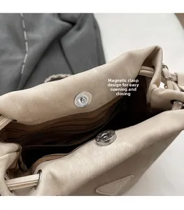 Detail view of the magnetic buckle design and striped lining on an off-white bucket bag