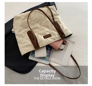 Top view showing the large capacity of a quilted cream tote bag with brown handles