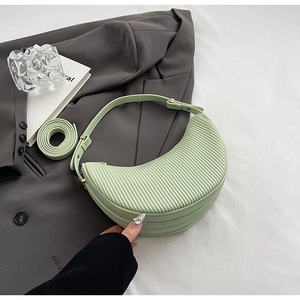 Detail view of light green pleated croissant bag with textured PU leather finish