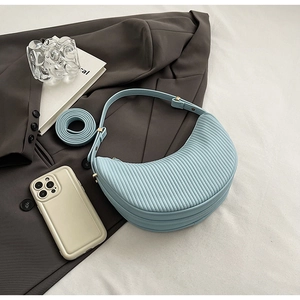 Detail of light blue pleated dumpling bag with vertical texture and shoulder strap