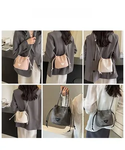 Detail view of drawstring bucket bags with chain straps in pink, beige, and grey colors