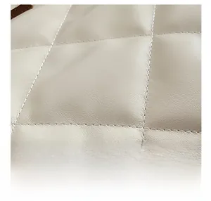 Macro view of cream quilted diamond pattern and detailed leather texture of the shoulder bag