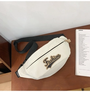 Vue détaillée d'un sac de poitrine en cuir blanc avec patch et sangle noire réglable