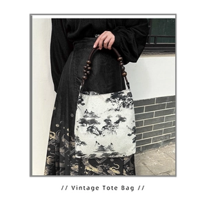 Close-up of ink wash painting print and wooden bead handle on vintage tote bag