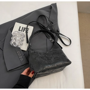 Detailed macro view of the black vintage cracked texture and sleek metal zipper on the bag