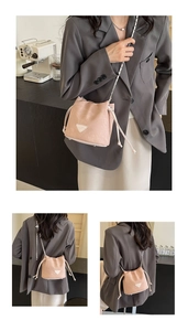 Detail of light pink drawstring bucket bag with silver chain strap and lychee leather