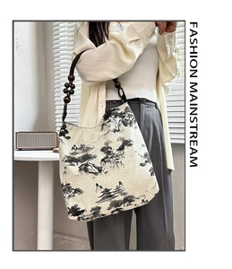 Detail of moss green tote with ink landscape print and beaded wooden handle