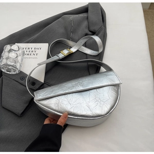 Detail view of silver pleated crescent bag with adjustable buckle strap and metallic texture