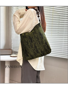 Detail of moss green tote bag featuring textured fabric and wooden bead shoulder strap