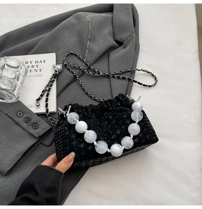Detail of black houndstooth pleated cloud bag with marble bead handle and chain strap