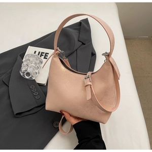 Detail of hobo bag in pearlescent pink finish with metal buckle and cracked texture
