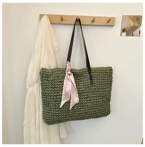 Detail of olive green woven straw bag with pink heart scarf and faux leather straps