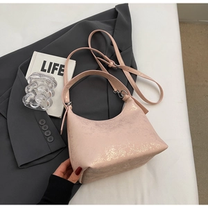 Close-up of pink crescent underarm bag with metallic texture and silver zipper details