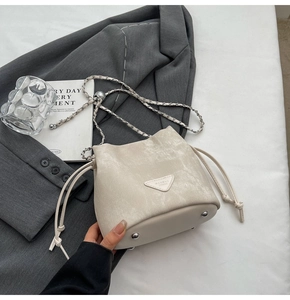Detailed shot of the cream velvet bucket bag with silver metal studs and leather drawstring