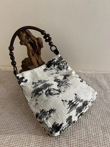 Detail view of oriental landscape print tote with wooden bead handle and texture fabric