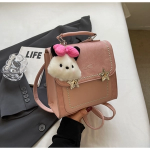 Detailed view of pink PU leather backpack with pearl trim and plush bear charm
