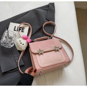 Detail of pink vintage backpack with silver star buckles, pearls and plush charm