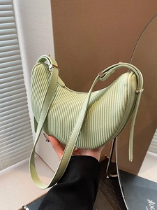 Pale green pleated croissant shoulder bag with modern crescent shape and metallic hardware