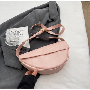 Detail view of pink pleated leather texture and embossed logo on minimalist shoulder bag