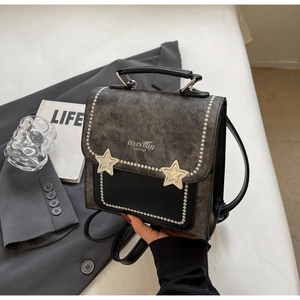 Detail of a vintage-style patchwork square backpack featuring silver studs and star accents
