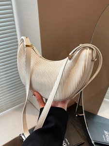 Chic beige pleated crescent shoulder bag with elegant vertical texture and thin strap