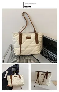 Detail of white quilted tote bag with brown handles and elegant diamond stitching