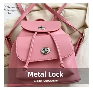 Close-up of pink leather backpack featuring dual silver metal twist-lock buckles