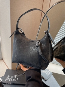 Chic vintage textured underarm bag with pleated details and adjustable strap shown by model