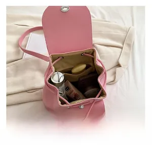 Top-down view of the pink backpack's spacious interior with drawstring and daily essentials